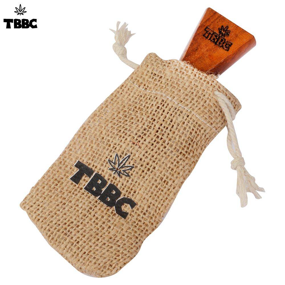 TBBC Double Barrel J Holder made of wood, displayed in a burlap sack with the TBBC logo printed on it.handcrafted wooden joint holder made by tbbc especially for homies who want to smoke 2 joints in 1, get highly fried/baked with double barrel and have real fun while taking cool and smooth toke every time you smoke. Weed lovers gets mad when they see this Magical toy in your hand.