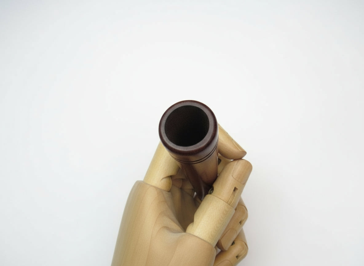 Hand holding a small brown bottle against a white background, top view of chillum mouth, weed wooden sadhu ganja chillums, easy to clean & carry chillums