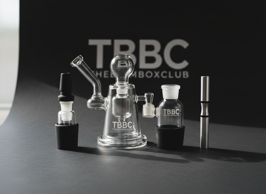 TBBC Mini Oil Rig, Mini Pocket Bong, and One Hitter SLYM Shady arranged on a dark premium background