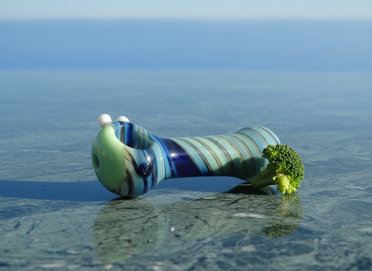 Blue swirl glass hand pipe on green marble surface — premium glass smoking pipe India, smooth pulls, TBBC