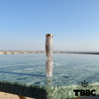 TBBC handcrafted big epoxy resin filter tip with marble grey swirls, brass ring and contoured body on marble and sky background