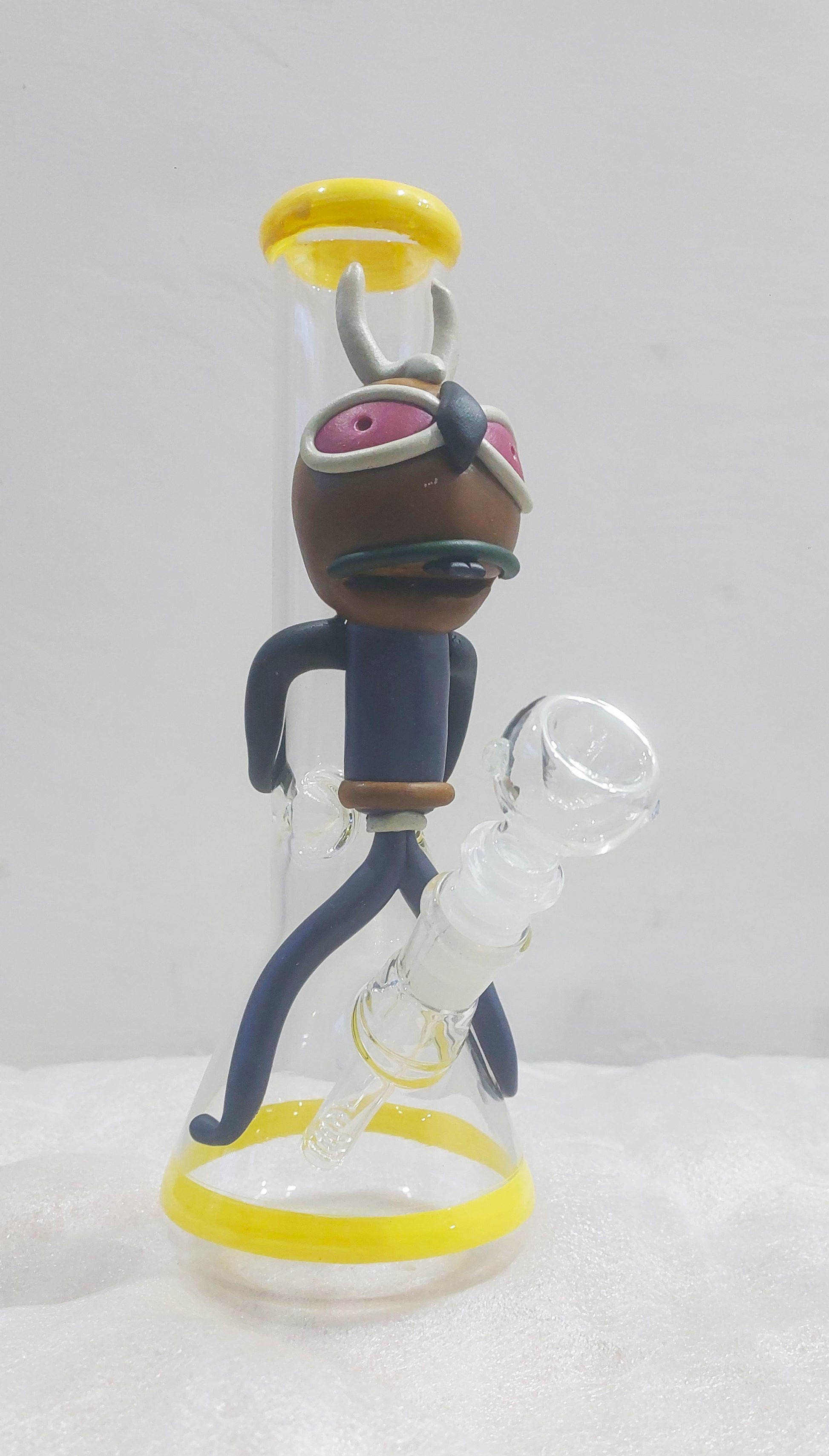 Animated character figurine with a white background, Close-up of a Trippy acid boy glass dick bong with yellow and black parts on a white background, instant delivery in delhi ncr, pan india smoking accessories brand tbbc theboomboxclub