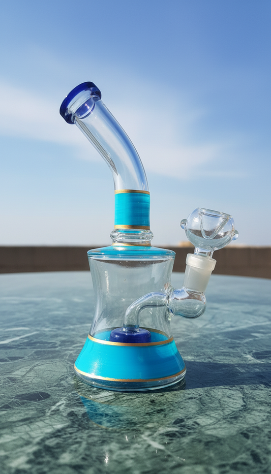 Glass water pipe with blue base and accents on a reflective surface with a clear sky background, bongs instant delivery in delhi ncr
