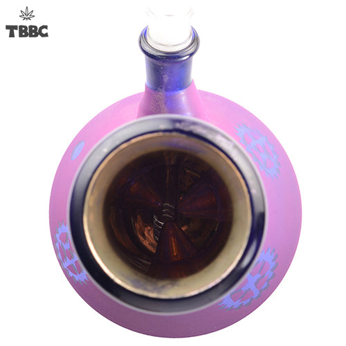 Pink glass bong with blue designs filled with a dark liquid on a white background, featuring the TBBC logo.