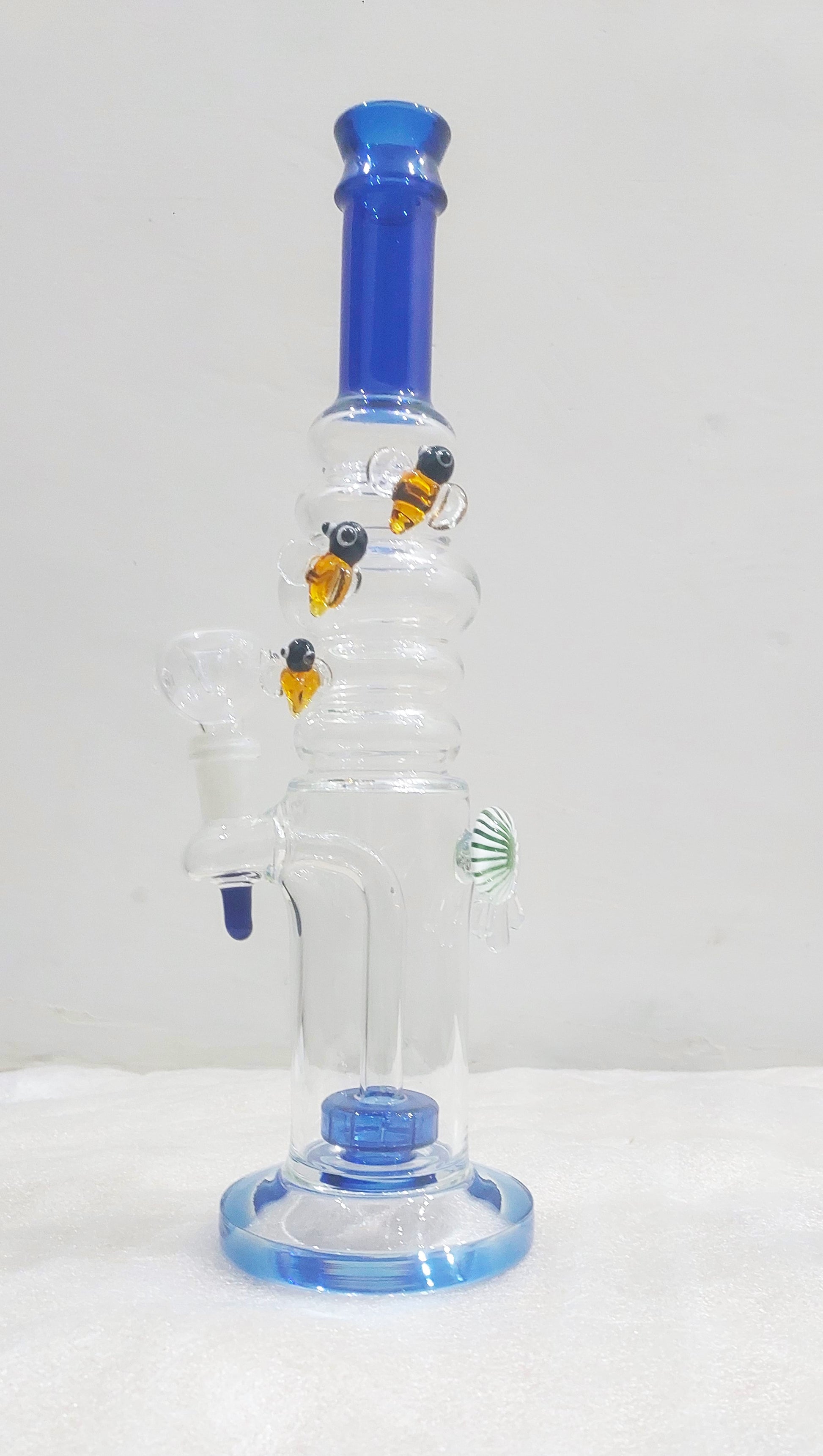 Glass water pipe with blue accents on a white background, Bees on Rings
Watching every bong rip
Heavy Borosil blow handcrafted glass piece with a Fish eye