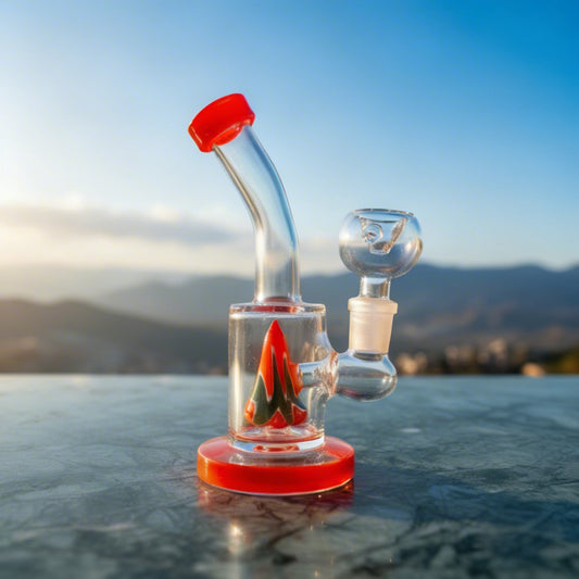 Glass water pipe with red accents on a reflective surface with a mountainous background, bongs instant delivery in delhi ncr