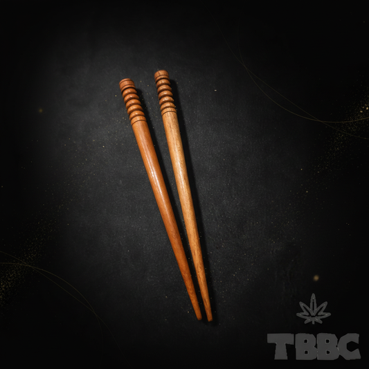 Two wooden chillum cleaning sticks on dark luxury background, handcrafted wood cleaning tool