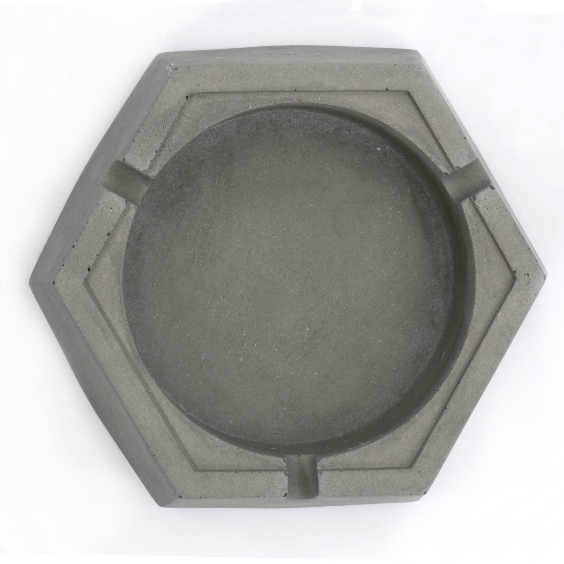 A dark, concrete ashtray with a geometric hexagonal shape, featuring a smoker holding a cigarette.hexagon greyt dankest stoner ashtrays, cement handcrafted home decor lifestyle ashtray,best cigarette_ashtray online nearby instant delivery