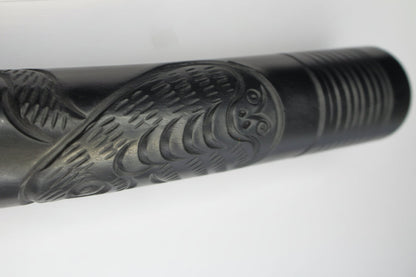 Decorative black metal object with engraved design on a white background