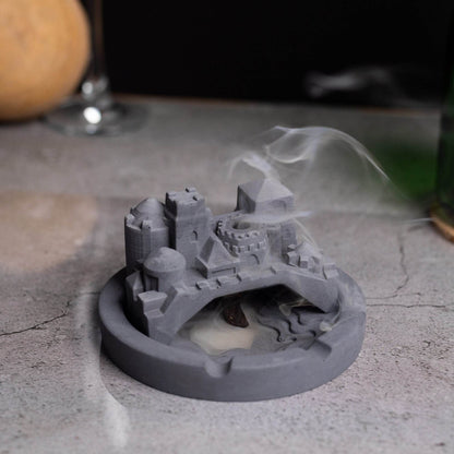 A gray Cosmic City Ashtray with a cityscape design, featuring a bridge and buildings, where smoke is intended to be released. Budget friendly durable cost efficient reasonable quality greyt ashtrays