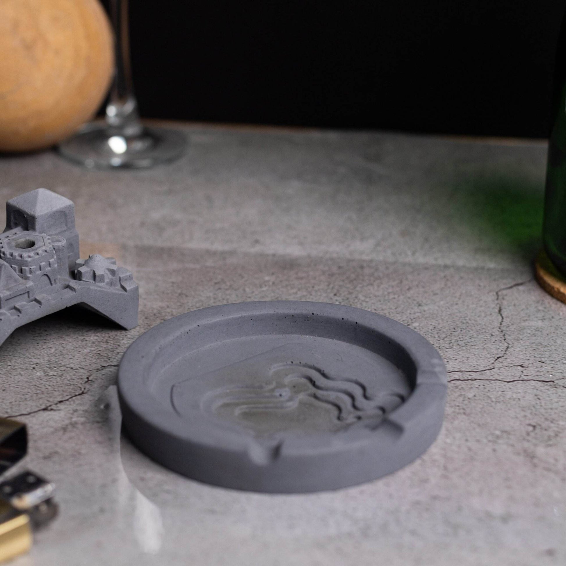 A gray Cosmic City Ashtray with a cityscape design, featuring a bridge and buildings, where smoke is intended to be released. Budget friendly durable cost efficient reasonable quality greyt ashtrays