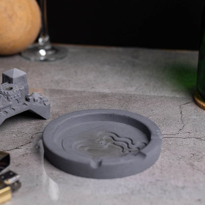 A gray Cosmic City Ashtray with a cityscape design, featuring a bridge and buildings, where smoke is intended to be released. Budget friendly durable cost efficient reasonable quality greyt ashtrays