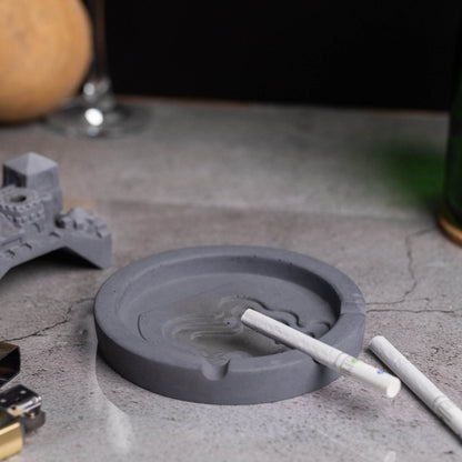 A gray Cosmic City Ashtray with a cityscape design, featuring a bridge and buildings, where smoke is intended to be released. Budget friendly durable cost efficient reasonable quality greyt ashtrays, cigarette weed joint rolling paper bong ashtray