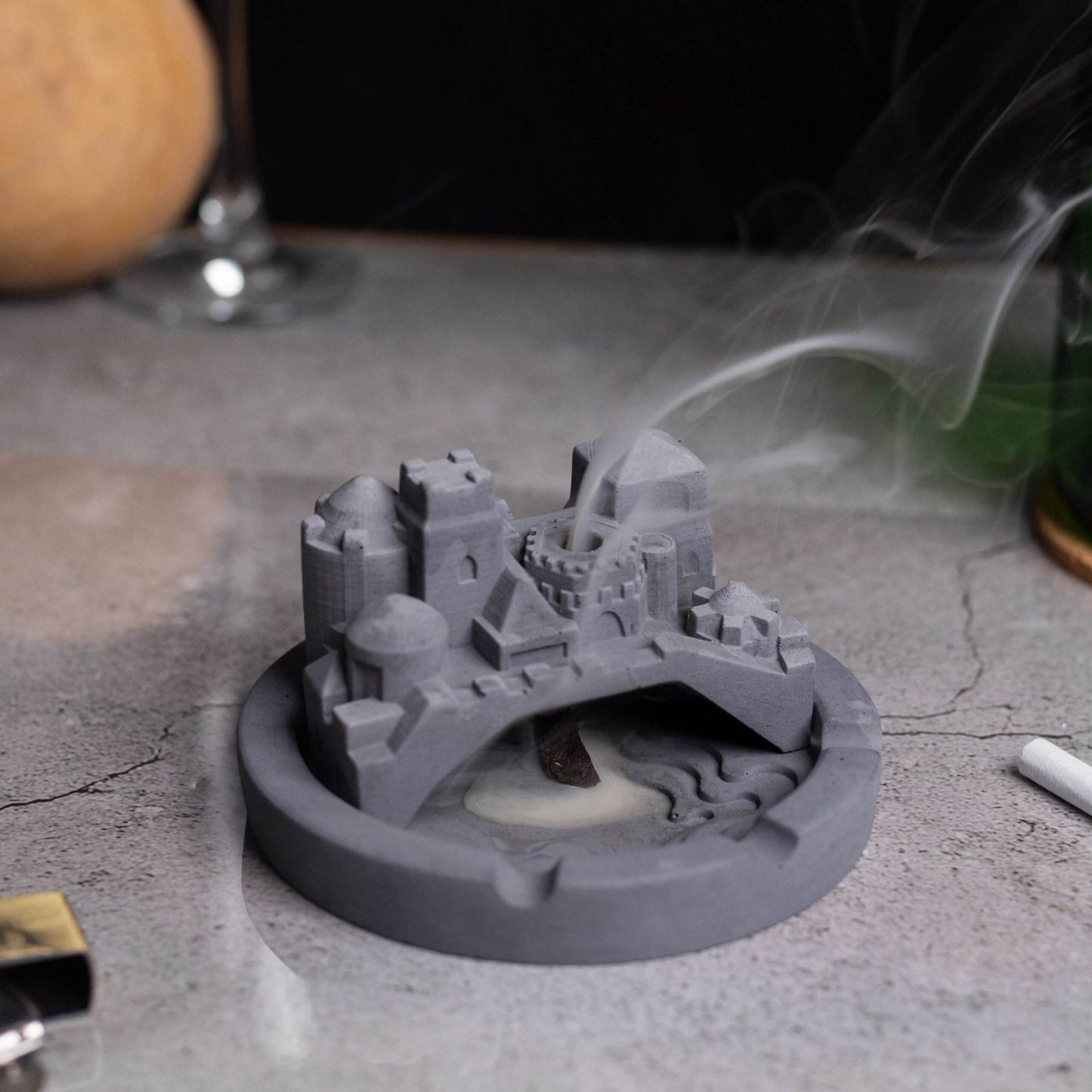 A gray Cosmic City Ashtray with a cityscape design, featuring a bridge and buildings, where smoke is intended to be released. Budget friendly durable cost efficient reasonable quality greyt ashtrays, cigarette weed joint rolling paper bong ashtray