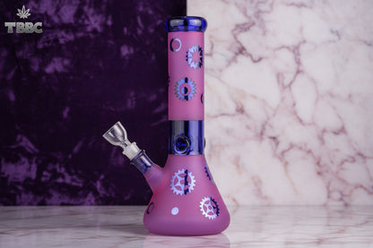 A 12 inch tall heavy ice bong with a purple base and blue top, featuring a geometric pattern design. Instant delivery in delhi ncr, express delivery pan india, exporter for exclusive bongs india