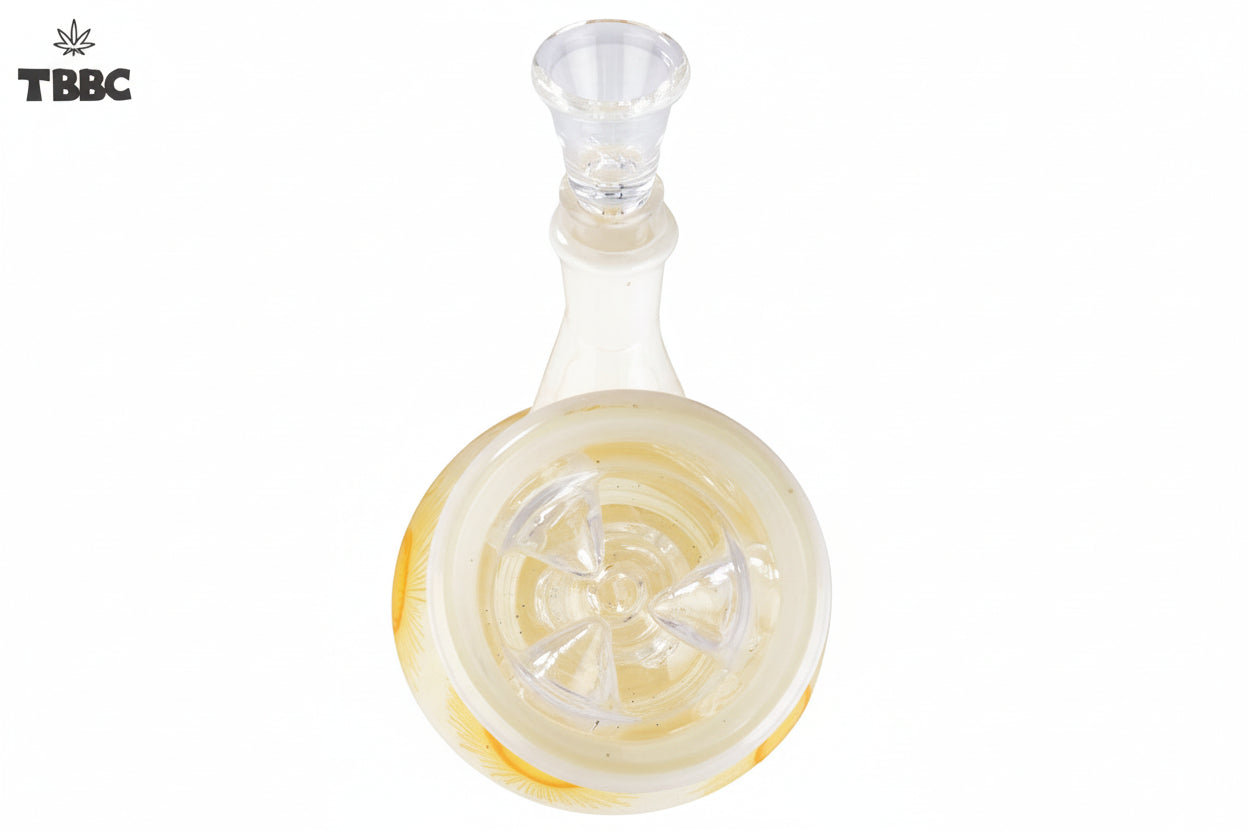 A beige-colored glass bong with a sunburst pattern, featuring yellow and orange hues, and ice spikes on the side, top view.